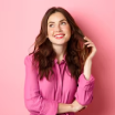 Smiling woman with auburn hair in a pink shirt